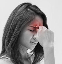 Woman holding forehead in pain