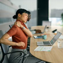 Woman working at laptop with shoulder pain