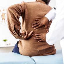 Person and doctor evaluating back pain