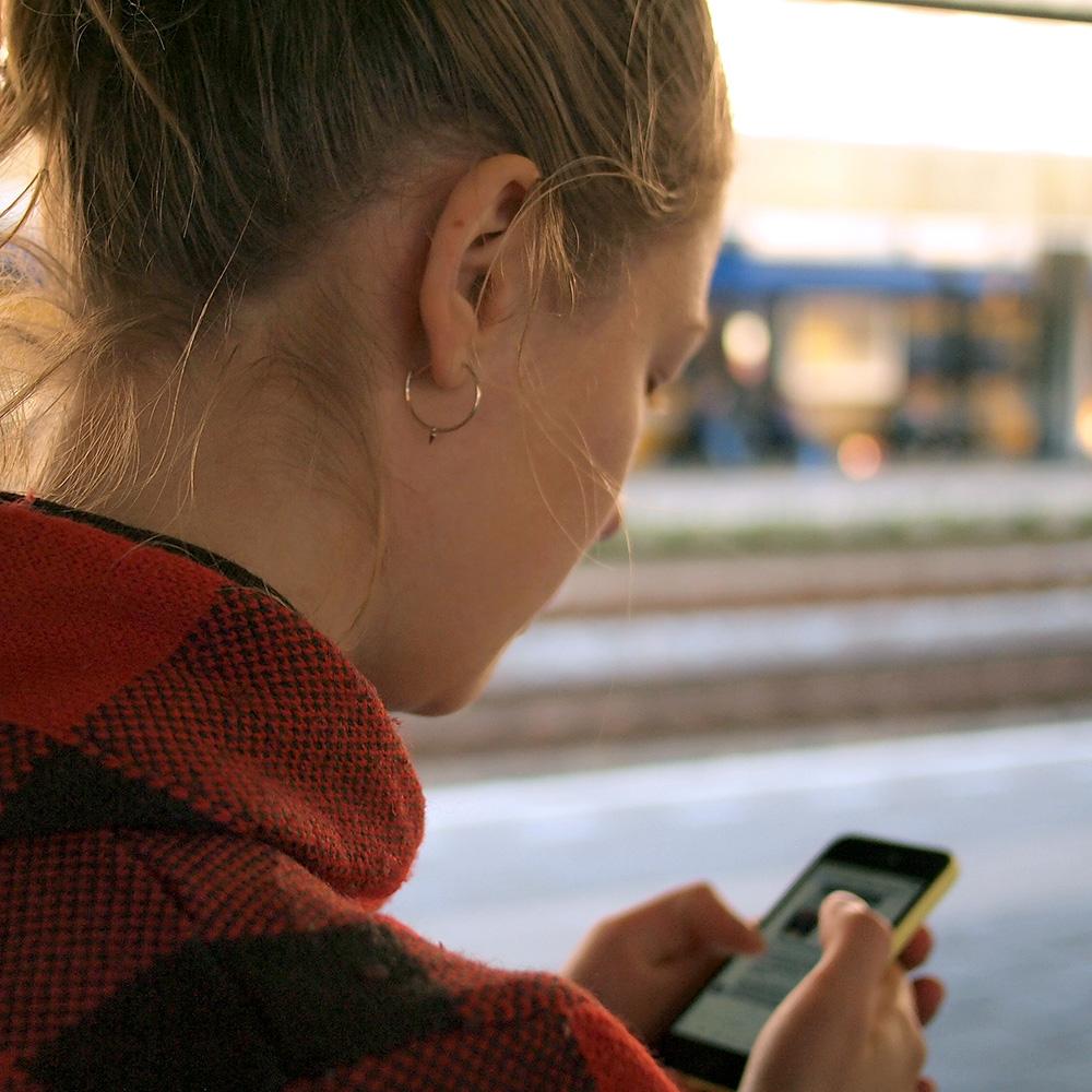 Young Woman Texting on Phone While Looking Down