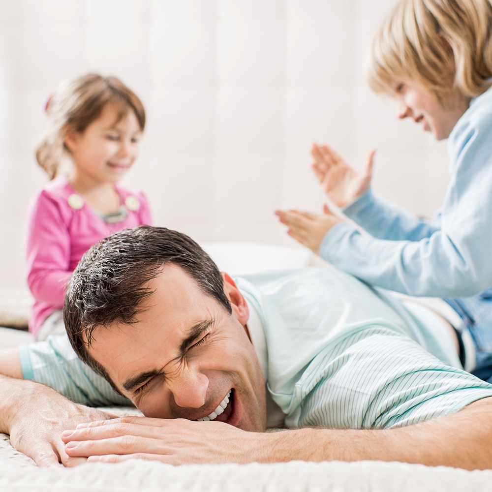 Dad with children getting play back massage
