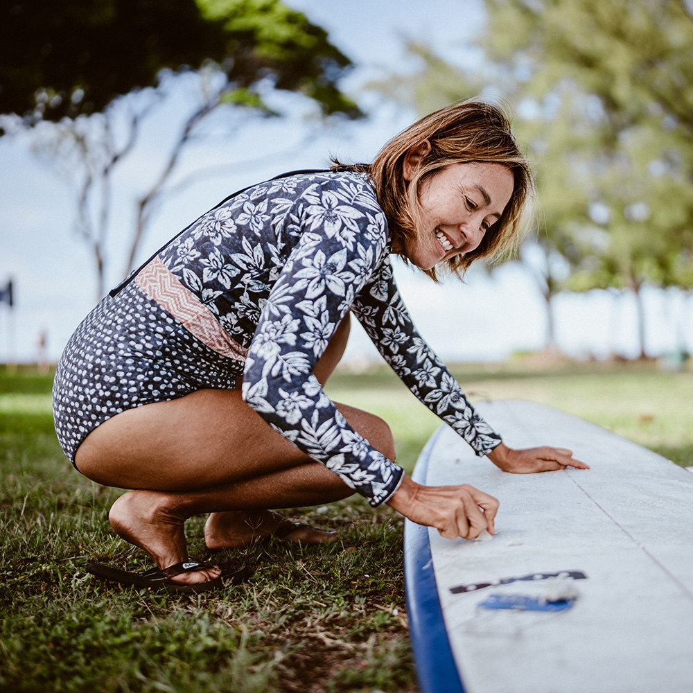 Woman waxing surfboard in Honolulu