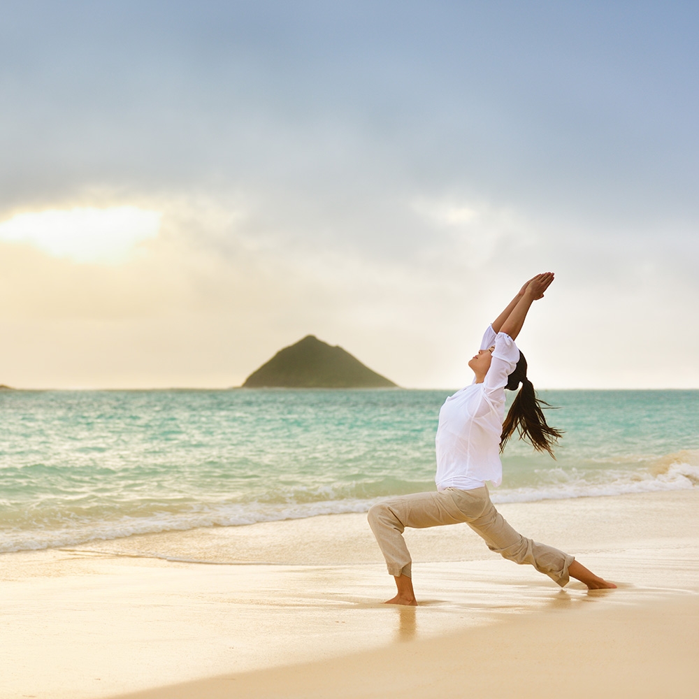 Woman doing yoga on the beach in Oahu