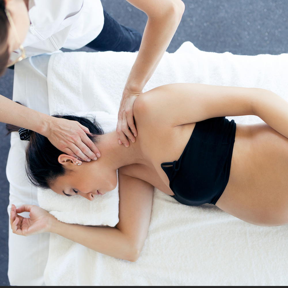 Chiropractor treating pregnant woman in clinic