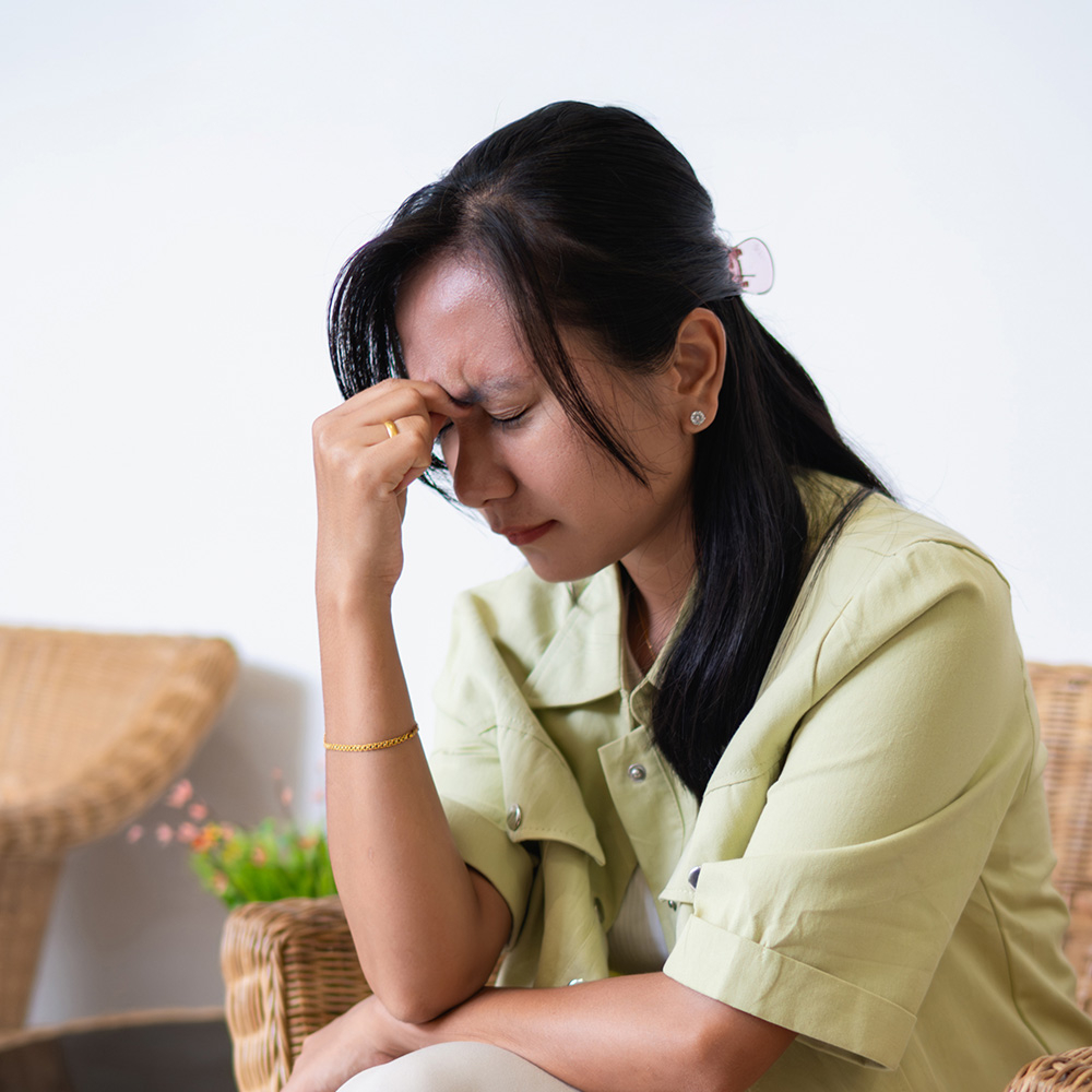 Woman holding head with pain due to stress