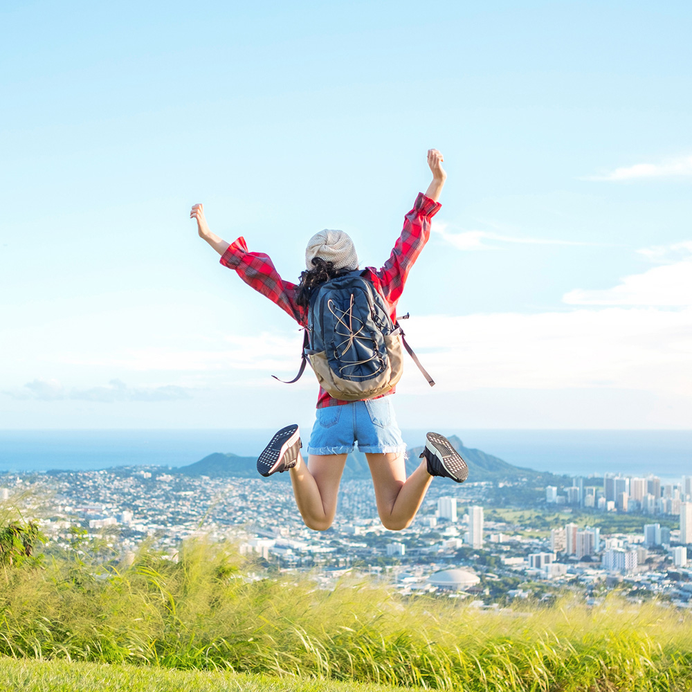Young woman jumping in the air while hiking Tantalus mountain